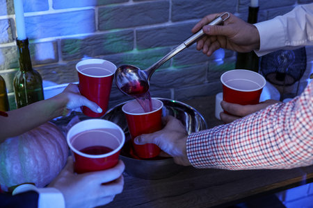 Young friends drinking punch at Halloween party, closeupの写真素材