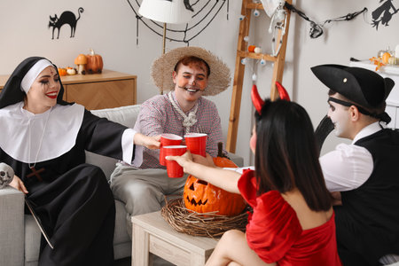 Group of friends in costumes drinking at Halloween partyの写真素材