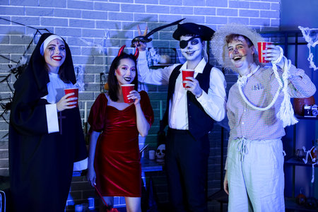 Group of friends in costumes drinking at Halloween partyの写真素材