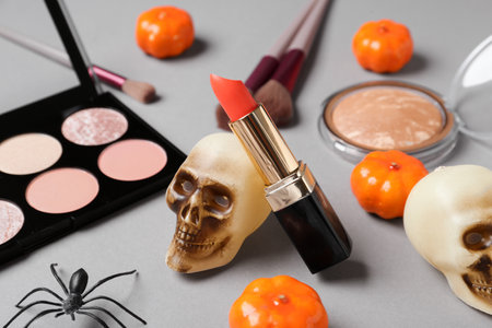 Different decorative cosmetics and Halloween decor on gray backgroundの写真素材