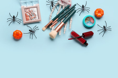 Different decorative cosmetics with pumpkins and spiders for Halloween on blue backgroundの写真素材