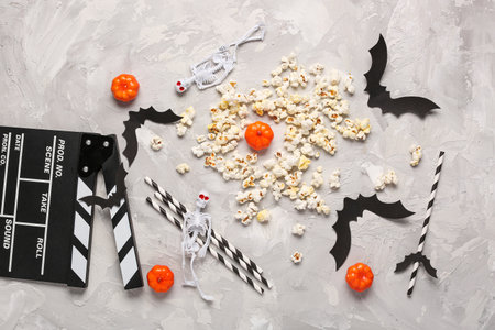 Movie clapperboard, popcorn and Halloween decor on gray grunge backgroundの写真素材