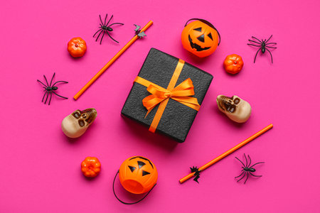 Composition with gift box and Halloween decorations on pink backgroundの写真素材