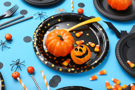 Festive table setting with Halloween decorations on blue backgroundの写真素材