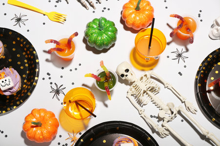 Party table setting with Halloween decor on white backgroundの写真素材