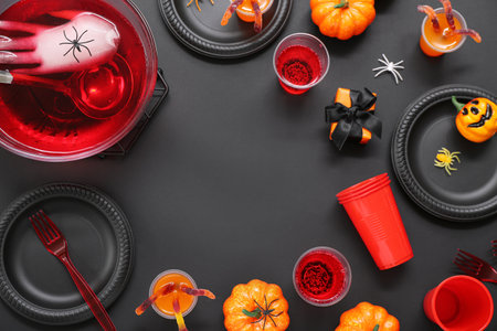 Halloween party table setting with punch and decor on black backgroundの写真素材