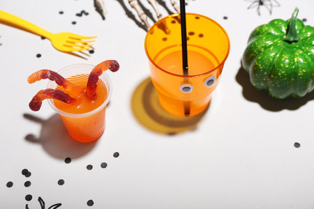 Halloween party table setting with punch and gummy worms on white backgroundの写真素材