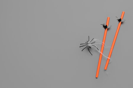 Drinking straws with Halloween decorations on gray backgroundの写真素材