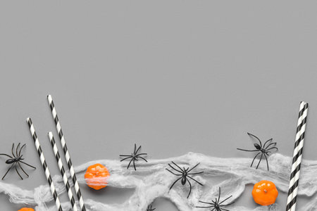 Composition with drinking straws and Halloween decorations on gray backgroundの写真素材
