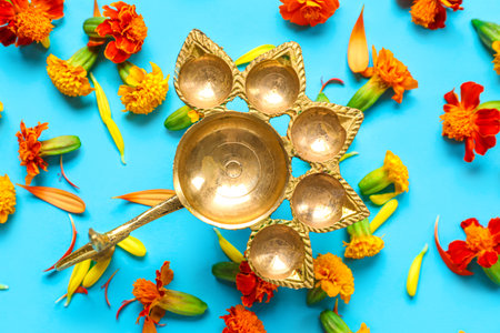 Diya lamp with marigold flowers on blue background. Divaly celebrationの写真素材