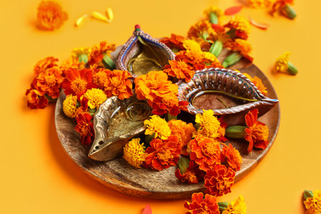 Diya lamp with marigold flowers on orange background. Divaly celebrationの写真素材