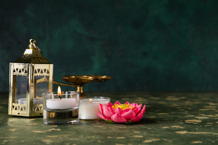 Diya lamps with candles and lotus flower on grunge green background. Divaly celebrationの写真素材