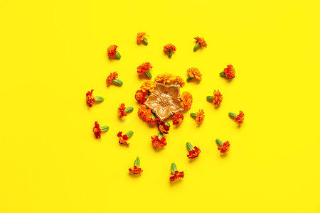 Diya lamp with marigold flowers on yellow background. Divaly celebrationの写真素材
