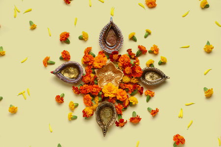 Diya lamps with marigold flowers on pale yellow background. Divaly celebrationの写真素材