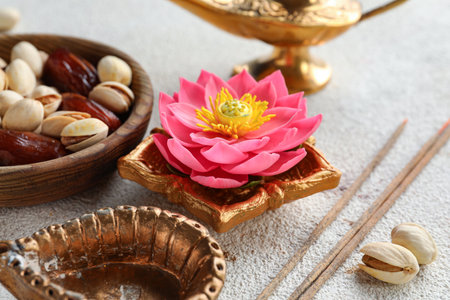 Diya lamps with incense sticks, lotus flower and bowl of treats on grunge white background. Divaly celebrationの写真素材