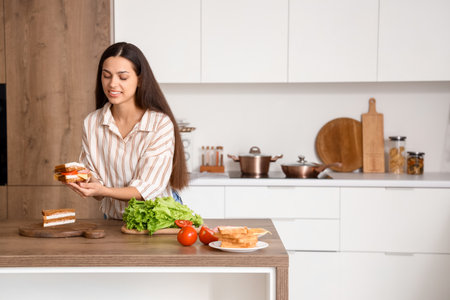 Young woman making tasty sandwich in kitchenの写真素材