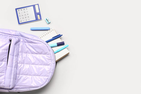 Stylish school backpack with different stationery supplies on gray background