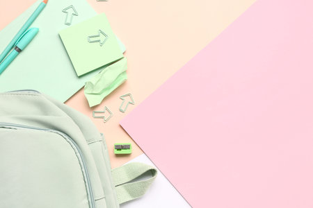Stylish school backpack with different stationery supplies on colorful backgroundの写真素材