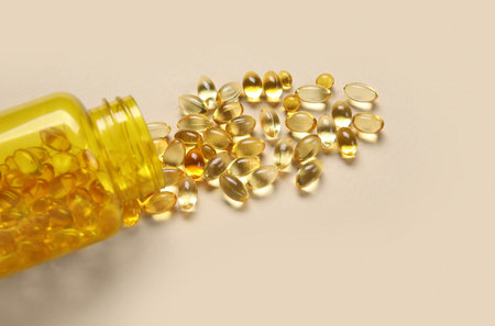 Jar with scattered pills on beige backgroundの写真素材