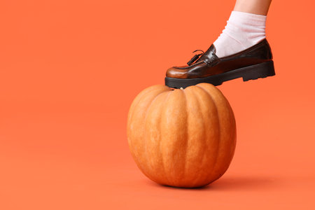 Young woman with pumpkin on orange background, closeupの写真素材
