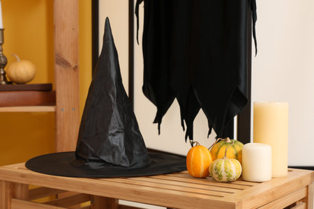 Witch hat with Halloween pumpkins and candles on drawer in living room, closeupの写真素材