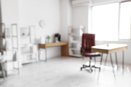 Blurred view of modern light office with comfortable workplaceの写真素材