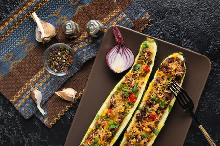 Plate with meat stuffed zucchini boats on black backgroundの写真素材