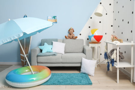 Interior of children's room with gray sofa and beach accessoriesの写真素材