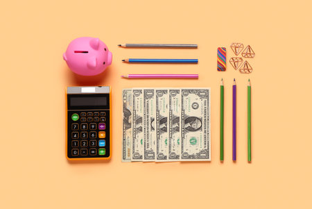 Different school stationery, piggy bank and money on beige backgroundの写真素材