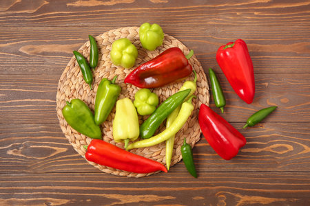 Different fresh peppers on wooden background