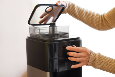Mature woman with coffee machine in kitchen, closeupの写真素材