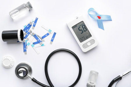 Glucometer, stethoscope, scarificators and blue ribbon on white background. Diabetes conceptの写真素材
