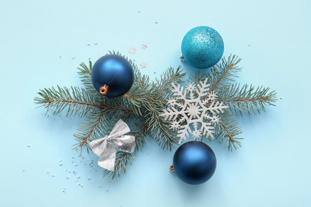 Christmas tree branches with balls, snowflake and bow on blue backgroundの写真素材