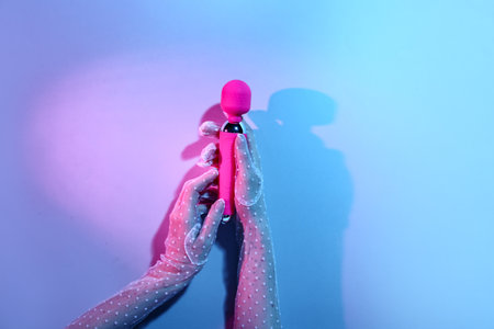Woman with vibrator on color backgroundの写真素材