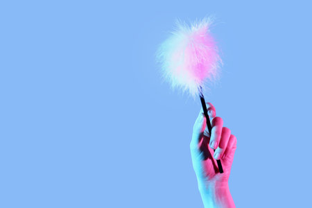 Woman with feather stick from sex shop on color backgroundの写真素材