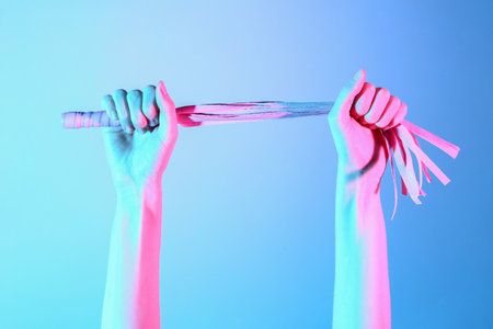 Woman with whip from sex shop on color backgroundの写真素材