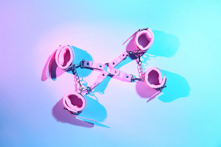 Strap with handcuffs from sex shop on color backgroundの写真素材