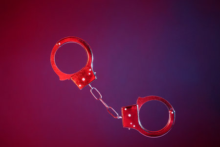 Flying handcuffs from sex shop on color backgroundの写真素材