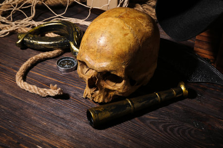 Human skull with travel equipment on brown wooden backgroundの写真素材