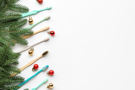 Toothbrushes with Christmas balls and fir branches on white backgroundの写真素材