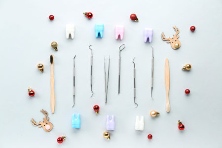 Dental tools with plastic teeth and Christmas decor on light backgroundの写真素材