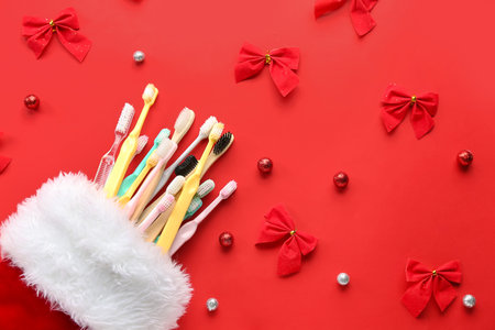 Christmas sock with toothbrushes, bows and balls on red backgroundの写真素材