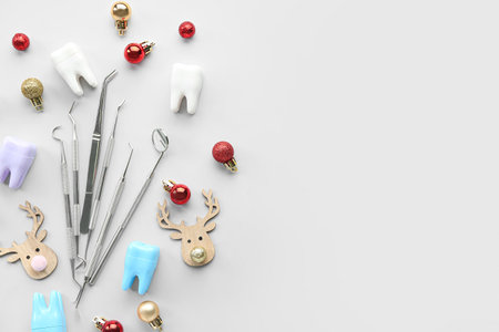 Dental tools with plastic teeth and Christmas toys on light backgroundの写真素材
