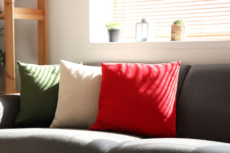 Gray sofa with pillows in colors of Italian flag at living room