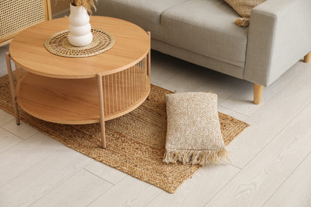 Interior of living room with wicker rug, wooden coffee table and gray sofaの写真素材
