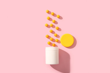 Jar with yellow pills on pink backgroundの写真素材