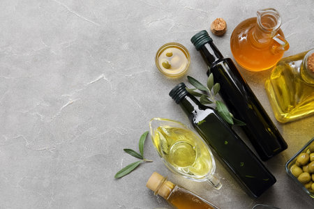 Different glassware with fresh olive oil on gray backgroundの写真素材