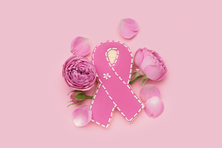 Cookie in shape of ribbon and rose flowers on pink background. Breast cancer awareness conceptの写真素材