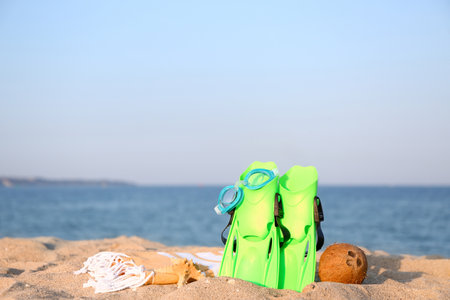 Set of beach accessories and ripe coconut on sea beachの写真素材