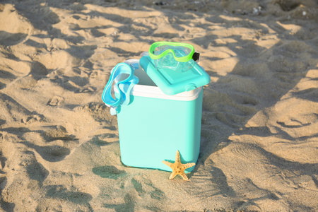 Beach cooler and snorkeling masks on sandの写真素材